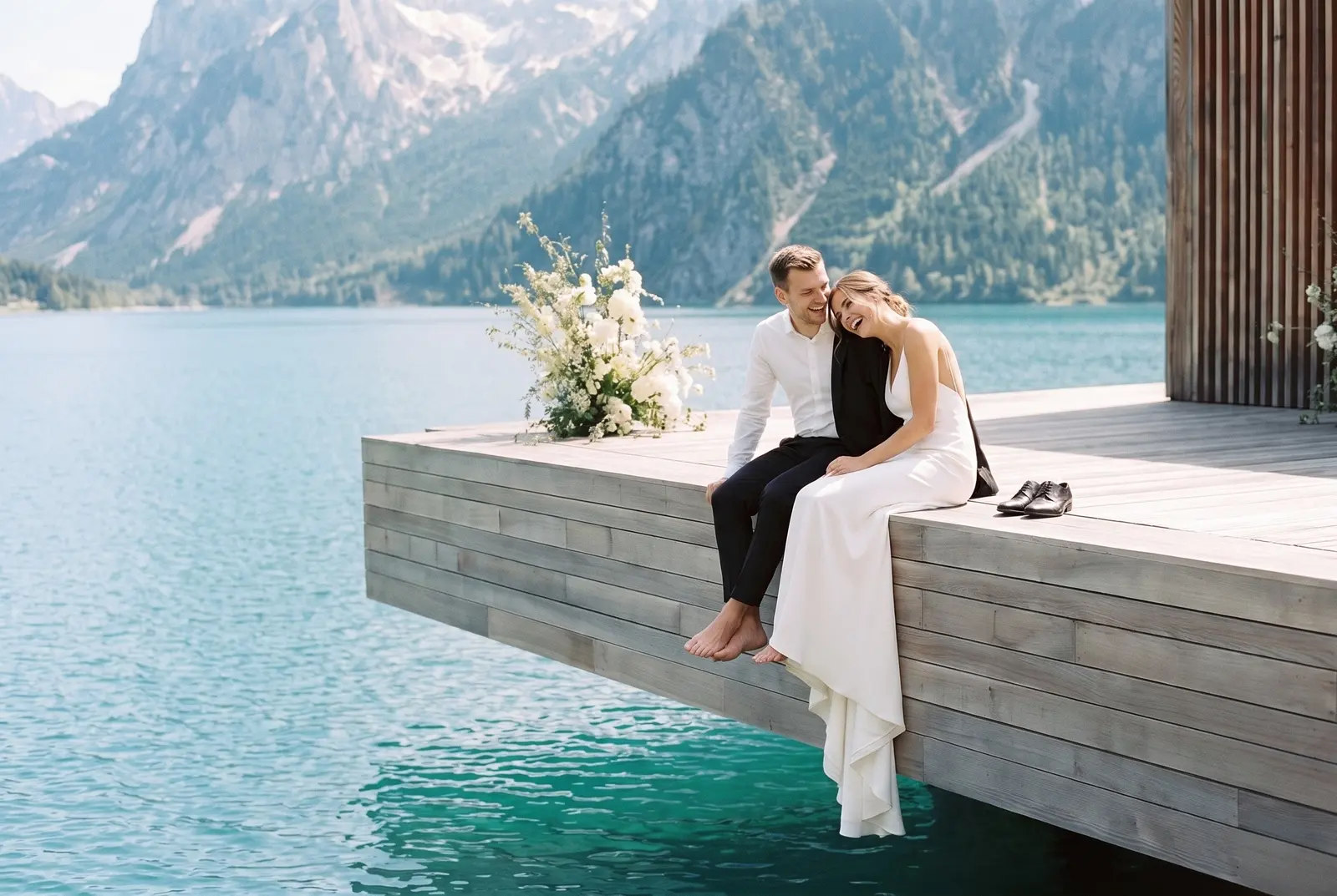 Lena und Tobias barfuß am Rand des Holzdecks über dem See